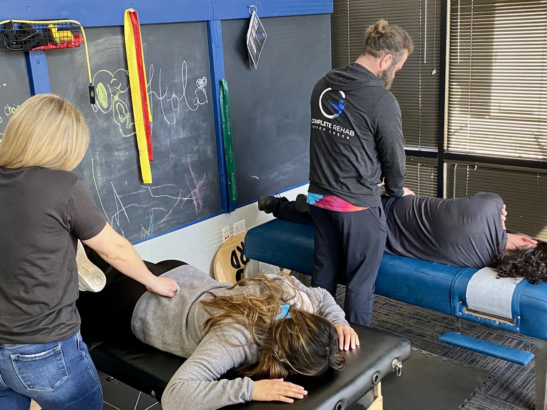 Profesionales de Complete Rehab QC atienden dos visitas de pacientes en la clínica.