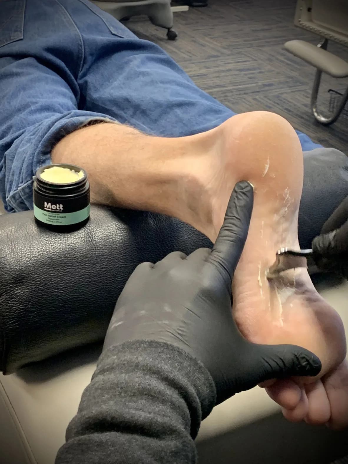 A clinician applies a scraping tool to soft tissue.